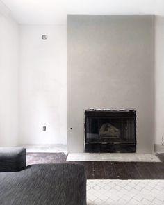 an empty living room with a fireplace and couches