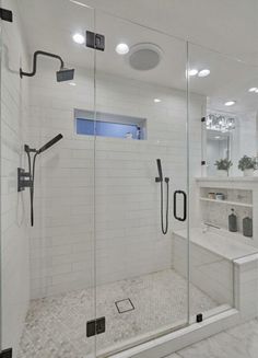 a walk in shower sitting next to a white sink and counter top under two lights