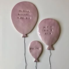 two pink balloons with names on them are attached to string and placed next to each other