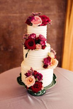 White three tiered wedding cake with ridged icing and pink and red floral cake decor. Frosted Wedding Cake, Layered Tulle Wedding Dress, Black Tie Wedding Reception, Wedding Cake Icing, Cake With Icing, Magenta Wedding, Wedding Bridesmaids Dresses Blue