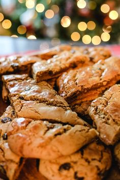 a plate full of cookies sitting on top of a table next to a christmas tree