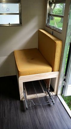 a yellow chair sitting on top of a wooden floor next to an open window in a room