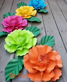 colorful paper flowers laid out on a wooden floor