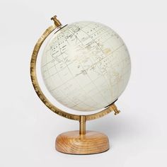 a white and gold globe sitting on top of a wooden stand