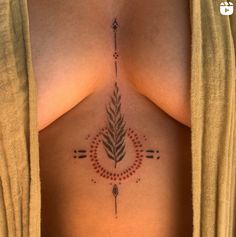 a woman's chest with an arrow and feather tattoo on her left side ribcage