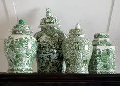 several green and white vases are sitting on a shelf