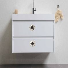 a bathroom vanity with two drawers and a faucet on the wall next to it