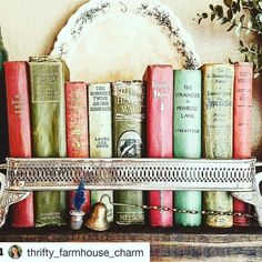 there is a shelf with many books on it and a mirror behind it that says thrift farmhouse charm