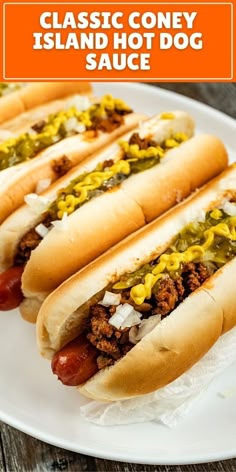 three hot dogs with mustard, relish and ketchup on a white plate