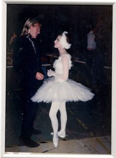 a man standing next to a woman in a tutu