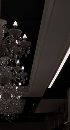 a chandelier hanging from the ceiling in a room with black walls and ceilings