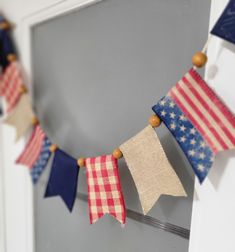 an american flag bunting is hanging on the door frame with wood beads and burlocks