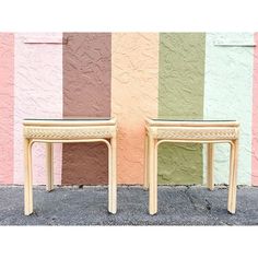 two wooden stools sitting next to each other in front of a multicolored wall