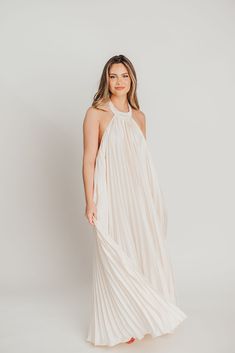 The Maren Pleated Halter Maxi Dress is an exquisite statement piece that exudes Greek-inspired elegance. Crafted from a lightweight cream fabric, it features a flattering drape, romantic silhouette, and classic pleating details. An exquisite choice for any special occasion. FIT: Runs true to size. MODEL: Mackenzie is 5’7” / 130lb / wearing a small. Heather is in her third trimester, wearing a small. MATERIAL: GARMENT DETAILS: Maxi dress with pleated details, halter neckline, and open back. MEASUREMENTS: (Note: flat lay measurements are approximate. Double the measurement for the full circumference of the garment). Spring Pleated Pre-draped Midi Dress, Elegant Beige Draped Dress, Wedding Pleated Maxi Dress With Pleated Bodice, Wedding Maxi Pleated Dress, Wedding Maxi Length Pleated Dress, Wedding Pleated Maxi Dress, Elegant Flowy Maxi Dress With Pleated Back, Cream Flowy Maxi Dress In Feminine Style, Cream Flowy Maxi Dress Feminine Style