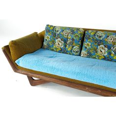 a couch with two pillows on it and a blue blanket over the backrests