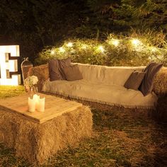 a couch sitting on top of a pile of hay next to a lit up sign