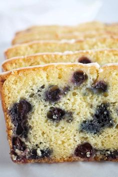 A sliced loaf of blueberry lemon bread with lemon glaze.