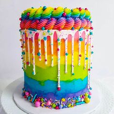 a multicolored cake with icing and sprinkles