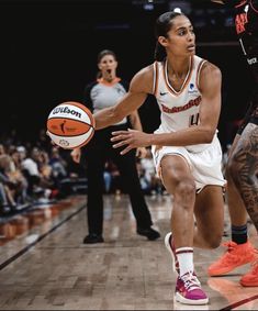 the basketball player is dribbling the ball while being guarded by two other players