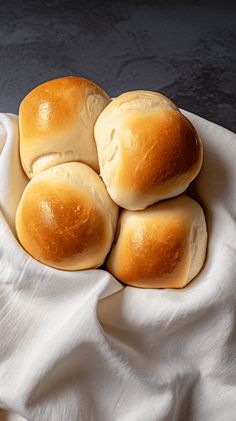 four rolls sitting on top of a white cloth