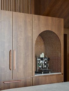 an espresso machine sitting on top of a counter next to wooden cupboards