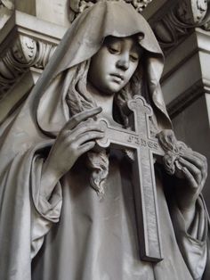 a statue of a woman holding a cross