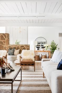 a living room filled with furniture and a stone wall