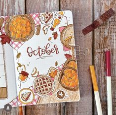 an open notebook with the word october written on it next to pencils and markers