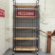 a metal shelf with some wooden shelves on it and a sign that says mezzanine