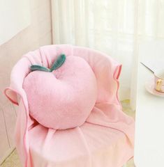 a pink chair with a heart shaped pillow on it