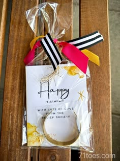 a happy birthday card on top of a wooden chair next to a tag and ribbon