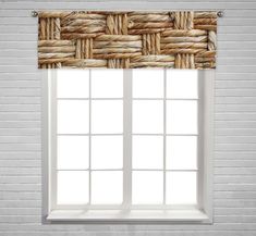 a window with a white brick wall behind it and a brown woven curtain hanging from the side