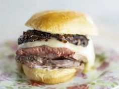 a close up of a sandwich on a plate with meat and cheese in the middle