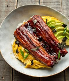 a plate that has some kind of food on it with avocado in the background