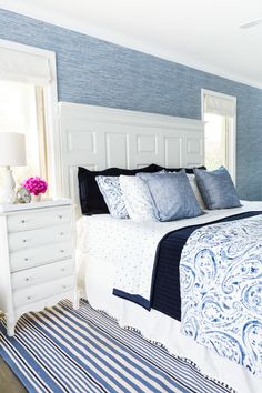 a bedroom with blue walls and white furniture