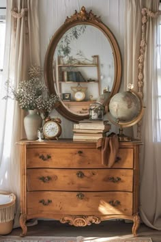 a dresser with a mirror, clock and flowers on it in front of a window