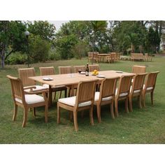 a large wooden table and chairs in the grass