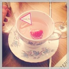 there is a tea cup with some liquid in it and a red triangle on the top