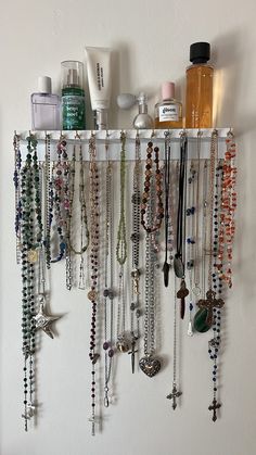 a white shelf filled with lots of necklaces and other jewelry hanging from it's sides