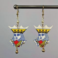 the earrings are decorated with an image of a woman's face and crown on them