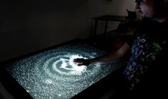 a man standing in front of a projection screen with his hand on the light table