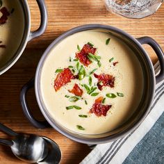 two bowls filled with soup on top of a wooden table