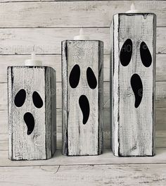 three white candles with black footprints on them