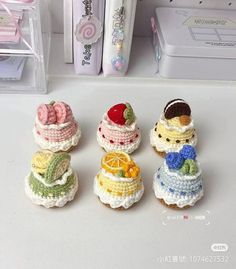 small crocheted cakes are sitting on a counter top next to pens and markers