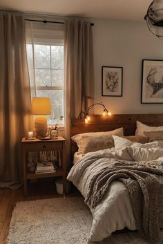 a bed sitting in a bedroom next to a window filled with curtains and lights on either side of the bed