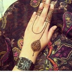 a woman's hand with henna tattoos and bracelets on top of it