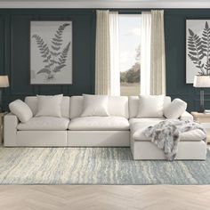 a large white sectional couch in a living room with blue walls and wood flooring