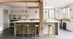 an open kitchen with bar stools next to the sink and stove top oven in it