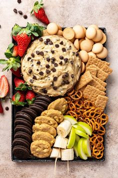 a platter filled with cookies, crackers and fruit