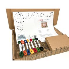 an open box filled with different colored crochet hooks